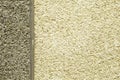 Stone wall, smooth surface, asphalt crumb, bitumen background. The trim is in beige and gray tones, separated by a cement vertical Royalty Free Stock Photo