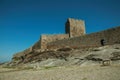 Stone wall and square tower from castle over rocky hill Royalty Free Stock Photo