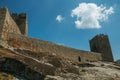 Stone wall and square tower from castle over rocky hill