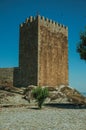 Stone wall and square tower from castle over rocky hill Royalty Free Stock Photo