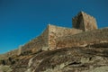 Stone wall and square tower from castle over rocky hill Royalty Free Stock Photo