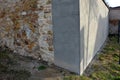 The stone wall surrounding the garden is restored on one side with cement plaster. landscaping in the courtyard. gray smooth surfa