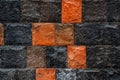 Stone wall texture close-up. Bright red, black and brown rock tile texture. Tile faceted stone wall background for design