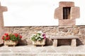 Stone wall with windowand stone benchon a street adorned with flower pots Royalty Free Stock Photo