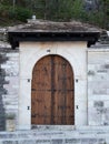 Stone Wall with Wooden Arched Door and Slate Roof Royalty Free Stock Photo