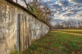 A stone wall with a worn wooden door in a rustic field setting Royalty Free Stock Photo