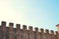 Stone walls of an old castle with battlements at the top Royalty Free Stock Photo
