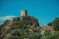 Stone walls and tower of castle over rocky cliff