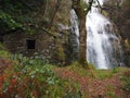 A stone water mill near a waterfall in an autumn forest Royalty Free Stock Photo