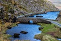 Stone Wishing Bridge over winding stream in green valley at Gap of Dunloe in Black Valley of Ring of Kerry, County Kerry