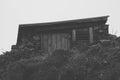 Stone wood shed in hillside from front black and white