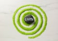 Stone with word Karma and circle made of light green sea salt on white marble table, top view Royalty Free Stock Photo