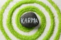 Stone with word Karma and circle made of light green sea salt on white marble table, top view Royalty Free Stock Photo