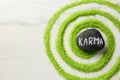 Stone with word Karma and circle made of light green sea salt on white marble table, top view . Space for text Royalty Free Stock Photo