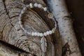 Stone yoga bracelet with metal feather pendant on wooden background Royalty Free Stock Photo