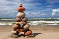 Stone zen pyramid made of colorful pebbles on the beach against a stormy sea Royalty Free Stock Photo