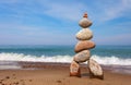 Stone zen pyramid made of colorful pebbles on the beach against a stormy sea