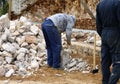 Stonecutter mason with hammer and stone working masonry Royalty Free Stock Photo