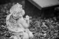 Stoned angel praying on tomb in cemetery