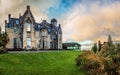 Stonefield Castle at sunset with bright green lawn in the front and some small bushes on the right in Argyll and Bute Scotland