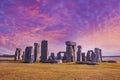 Stonehenge under dramatic sunset sky with long shadows