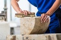 Stonemason brushing stone dust off workpiece Royalty Free Stock Photo