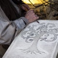 Stonemason carves and shapes the stone with a wooden hammer and chisel Royalty Free Stock Photo