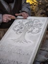 Stonemason carves and shapes the stone with a wooden hammer and chisel Royalty Free Stock Photo