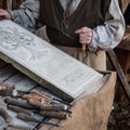 Stonemason carves and shapes the stone with a wooden hammer and chisel Royalty Free Stock Photo
