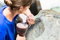 Stonemason working on boulder with sledgehammer and iron