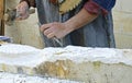 Stonemason working with hammer and chisel.