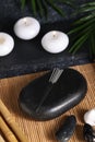 Stones with acupuncture needles and burning candles on bamboo mat Royalty Free Stock Photo