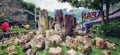 The stones are arranged into a beautiful sculpture in a natural setting surrounded by shady trees in sunny weather.