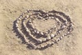 Stones arranged in heart shape on sand  summer sunny day  white rock  seacoast. Love symbol  heart shape Royalty Free Stock Photo