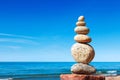 Stones balance on a background of blue sky and sea