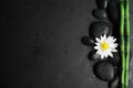 Stones, bamboo, lotus flower and space for text on black background, flat lay. Zen lifestyle