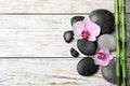 Stones, bamboo, orchid flowers and space for text on wooden background, flat lay. Zen lifestyle Royalty Free Stock Photo