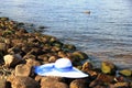 on stones Bank rivers white female hat with broad brim, blue ribbon