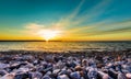 Stones on a beach with sunset on the ocean sea. Royalty Free Stock Photo