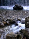 Stones and boulder in the river in front of a waterfall