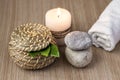 Stones, a candle, a jar and green leaves, a white rolled towel. Spa setting concept Royalty Free Stock Photo