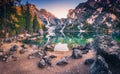 Stones on the coast of Braies lake at sunrise in autumn