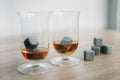 Stones for cooling whiskey and glases tulup on light wooden background