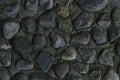 Stones dark black gray cement wall part of an old river mouth dried up close-up background design base