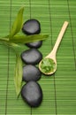 Stones and Green salt in wood spoon on green mat