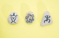 Stones with hand-drawn taino petroglyphs symbols, craft with children for Hispanic heritage month