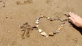 Stones in heart shape laid out by hand on sand of sesa beach Royalty Free Stock Photo