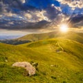 Stones on the hillside with lake at sunset Royalty Free Stock Photo