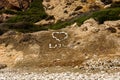 Stones inscribed `Love` word with a large heart on a beach at Aphrodite Rock in Cyprus Royalty Free Stock Photo