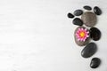 Stones with lotus flower and space for text on wooden background, flat lay. Zen lifestyle Royalty Free Stock Photo
